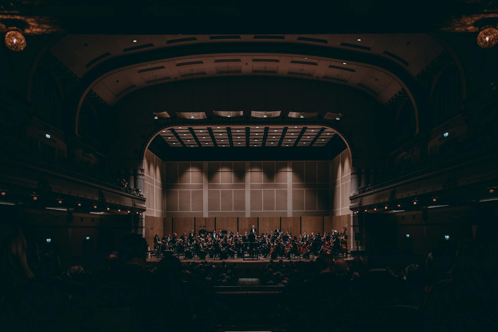 Orchestra performing in a grand concert hall as part of Manchester museums and cultural scene