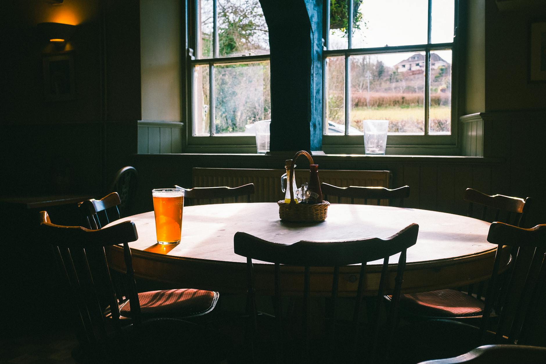 Manchester Trip Cost: Complete Budget Breakdown (2026) 4 Pint of beer on a wooden bar in a traditional English pub