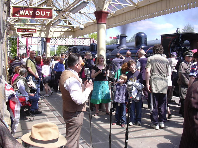 Bury: The Market, the Black Pudding & the East Lancashire Railway 7 Crowds and a 1940s-style singer on the platform at Ramsbottom station during a wartime weekend, with a steam engine behind