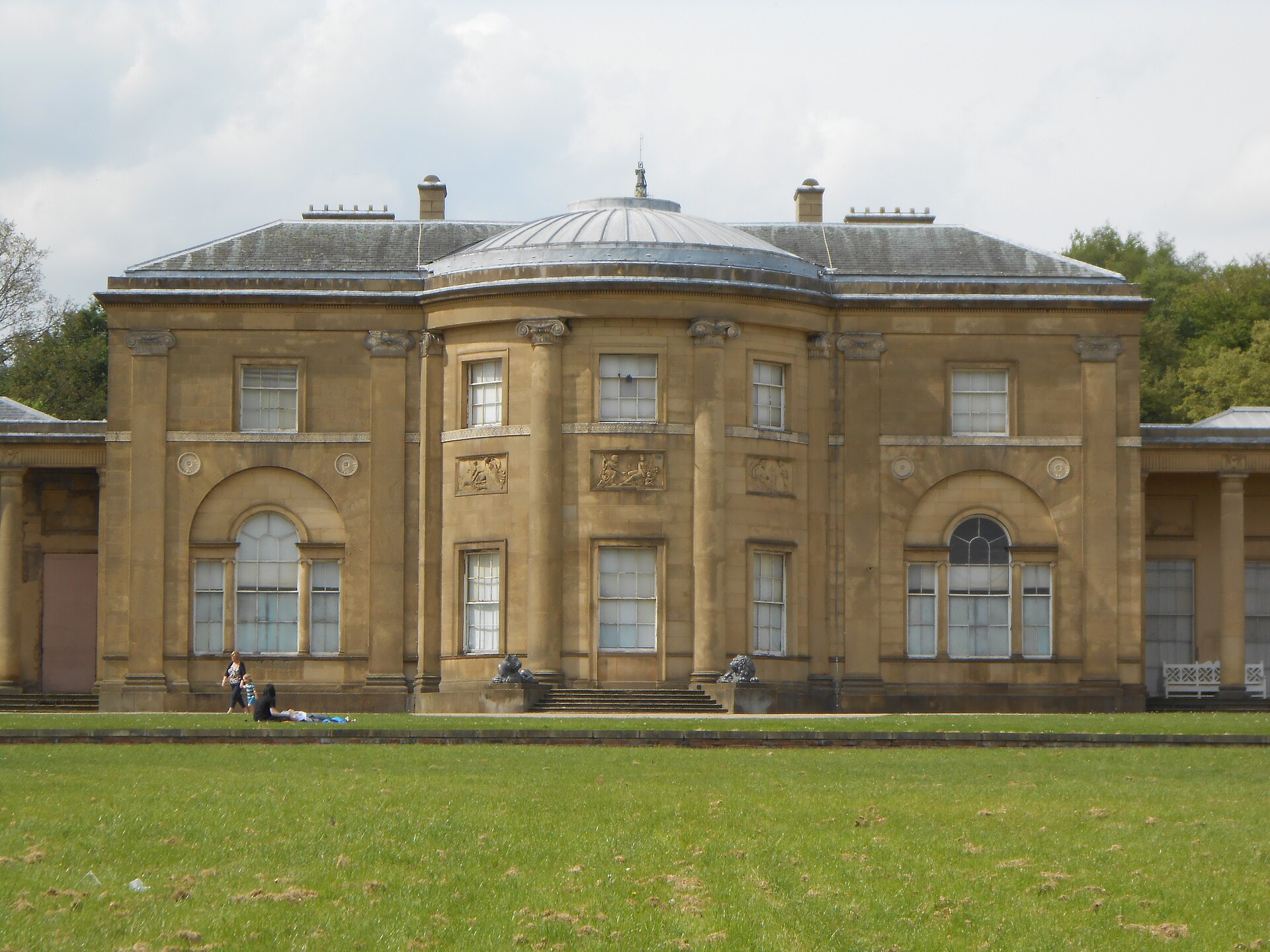 The domed neoclassical south front of Heaton Hall across a sunny lawn in Heaton Park