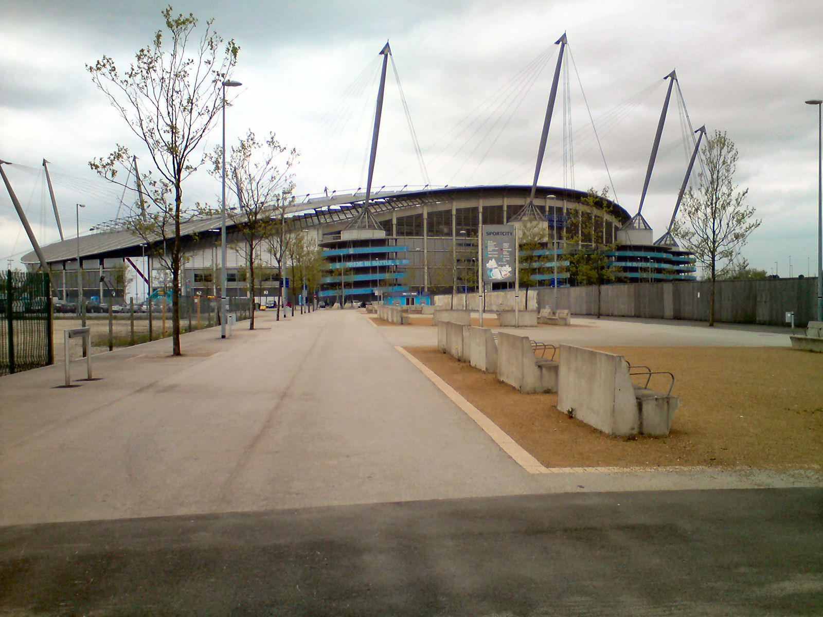 The Etihad Stadium and its mast-supported roof seen from the campus plaza