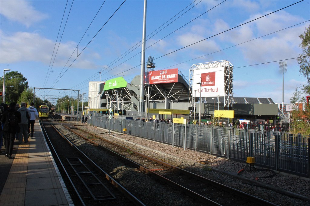 Old Trafford Metrolink stop with a tram arriving beside the Emirates Old Trafford cricket ground