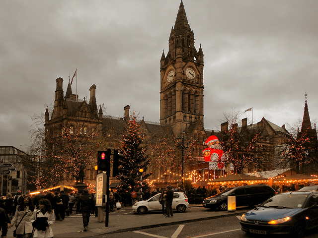 Manchester Month by Month: The Year-Round Visitor's Calendar 8 Manchester Town Hall clock tower above the Christmas market stalls in Albert Square at dusk