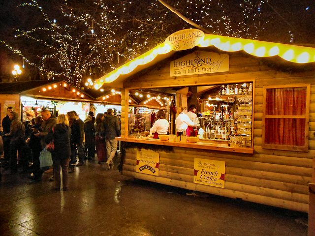 Manchester Christmas Markets Food & Drink: What to Eat & Drink 4 A lit wooden hot drinks chalet at the Albert Square Christmas market advertising Baileys and French coffee
