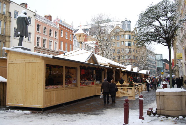 Manchester Christmas Markets Tips: Best Time, Parking & Avoiding Crowds 2 Wooden market chalets in a quiet, snowy St Ann's Square with a handful of shoppers