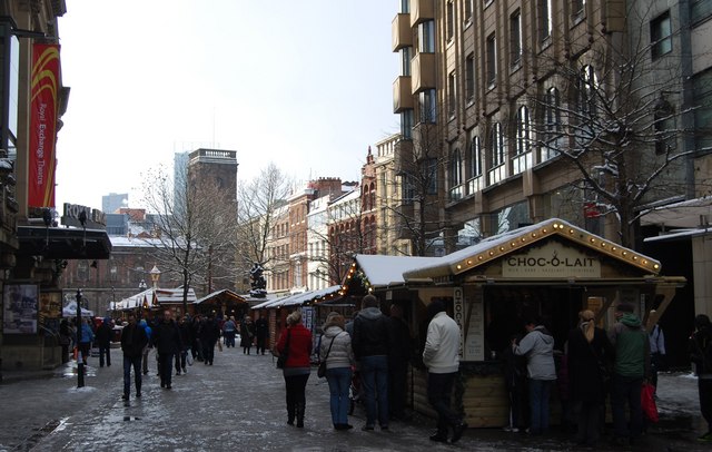 Manchester Christmas Markets Tips: Best Time, Parking & Avoiding Crowds 6 Shoppers walking between Christmas market stalls in St Ann's Square after snow