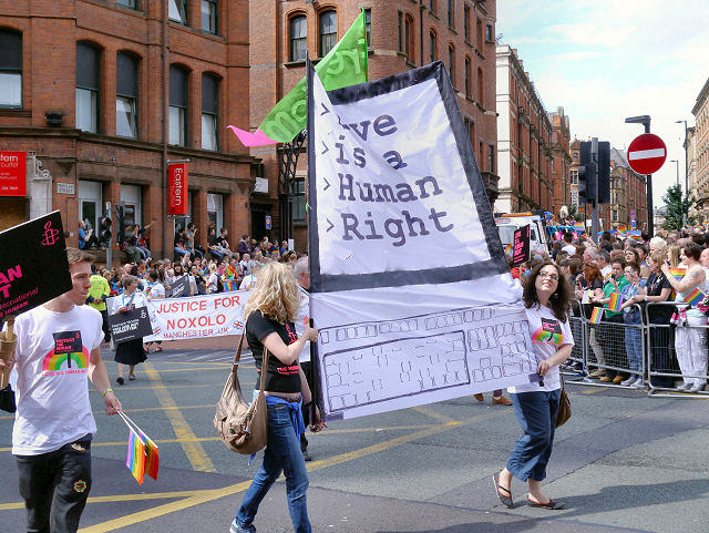 Manchester Month by Month: The Year-Round Visitor's Calendar 5 Marchers carrying a Love Is A Human Right banner past crowds at the Manchester Pride parade