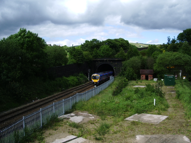 A passenger train emerging from the Standedge railway tunnel portal at Diggle