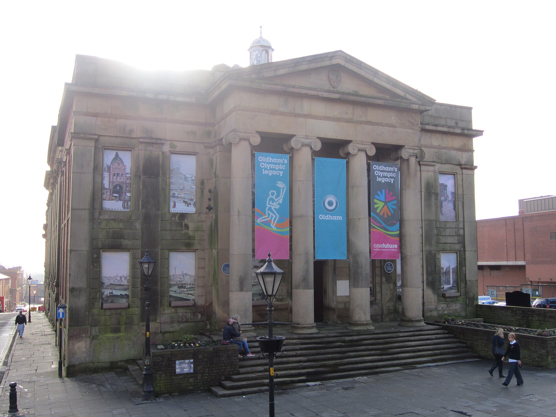 The classical columned front of Oldham's Old Town Hall with banners between the columns
