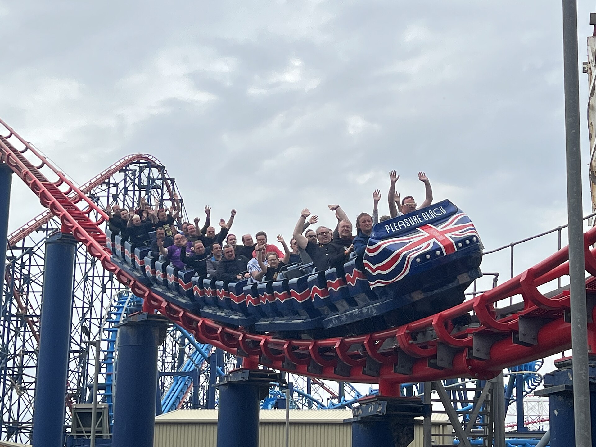 Alton Towers & Theme Parks Near Manchester 5 Riders with their arms raised on a Union Jack roller coaster train on the Big One at Blackpool Pleasure Beach