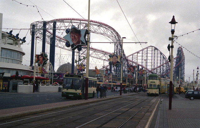 Alton Towers & Theme Parks Near Manchester 4 The red steel track of the Big One roller coaster above Blackpool promenade, with trams and the Pleasure Beach frontage