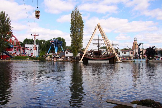Alton Towers & Theme Parks Near Manchester 7 A lake at Drayton Manor with fairground rides, a pirate ship swing and a cable car line beyond