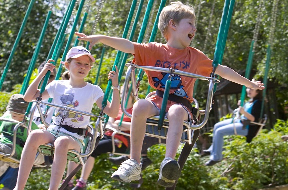 Alton Towers & Theme Parks Near Manchester 3 Two children laughing on a swing ride among trees at Gulliver's World in Warrington