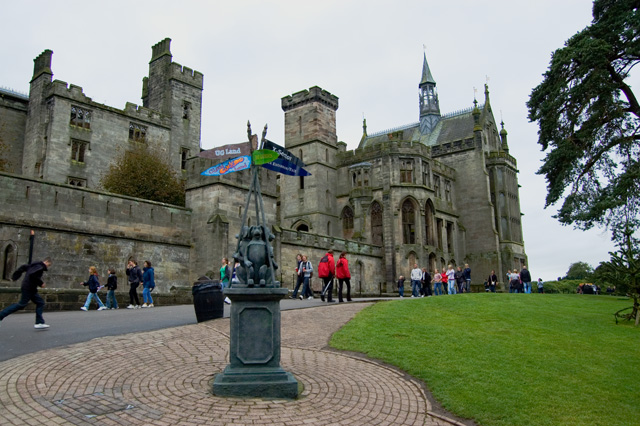 The stone Gothic towers and turrets of the old mansion at Alton Towers with visitors on the path in front